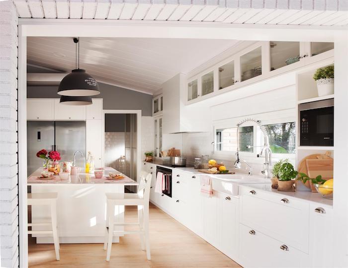 inbyggt kök, vit köksmodell med parkett i ljust trä, centralö och köksskåp i trä, svarta upphängningar, grå bänkskiva, takpanel i trä