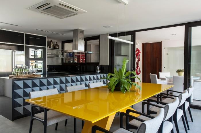 posuvné sklenené dvere, žltý obdĺžnikový stôl, sivé a drevené stoličky, kuchyňa a jedáleň