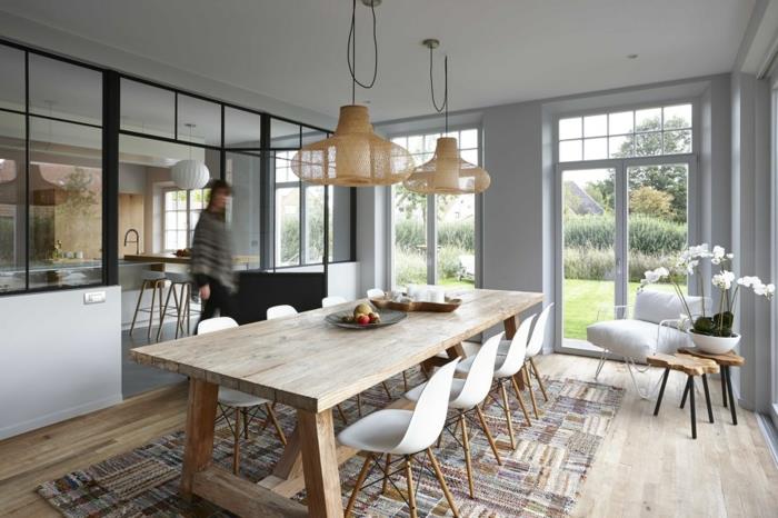 polootvorená kuchyňa so sklenenou priečkou, obdĺžnikový patchwork koberec, veľký jedálenský stôl, závesné žiarovky, jednopodlažný dom