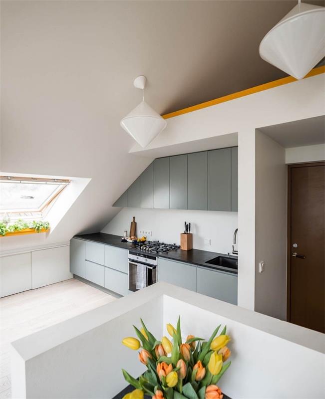 ett vindkök med en modern design med ett låssystem utan handtag, en vindsvåning med ett skräddarsytt kök