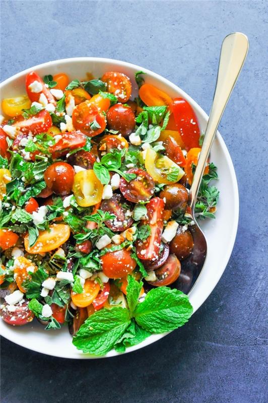 Stredomorský recept na miešaný zelený šalát, cherry paradajky, syr feta a čerstvé bylinky ako mäta, oregano a bazalka