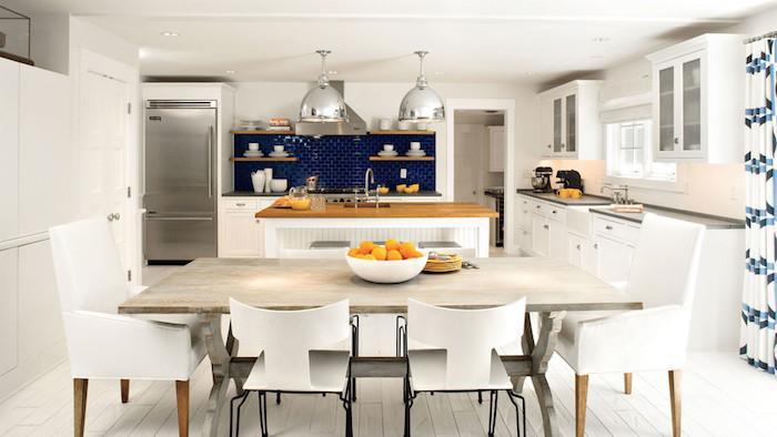 Modernt kök backsplash i marinblå kakel, vit bar med trä bänkskiva, gråaktigt träbord och vita stolar, vit parkett, grå metalliska taklampor