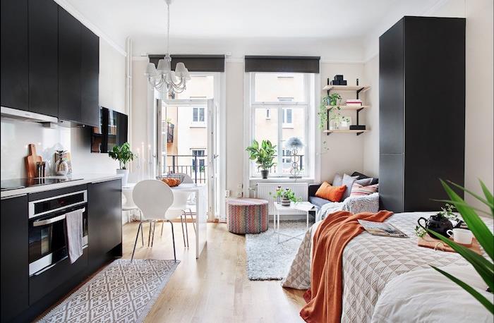 kök layout idé för ett litet svart utrymme framför ett sovrum hörn, svart skåp, vita väggar, litet vardagsrum med grå soffa, vitt fällbart soffbord