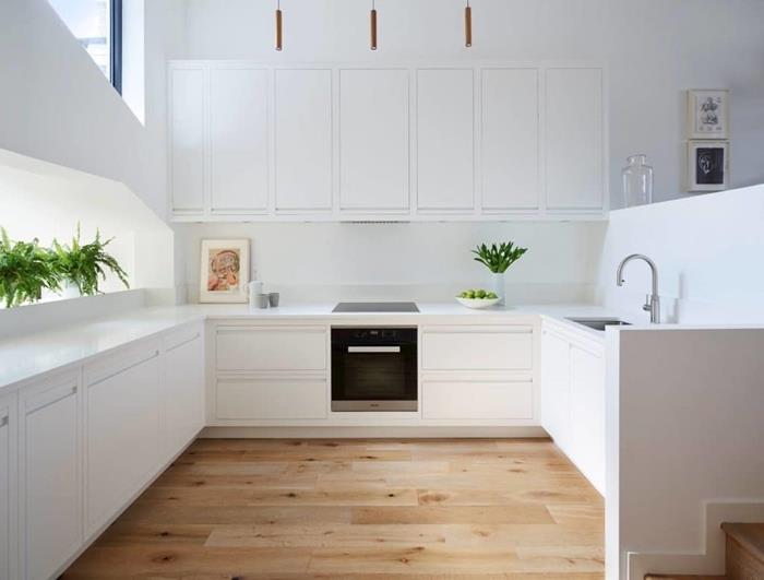 biela vybavená kuchyňa drevená parketa dekorácia otvorená kuchyňa biele skrinky biela pracovná doska