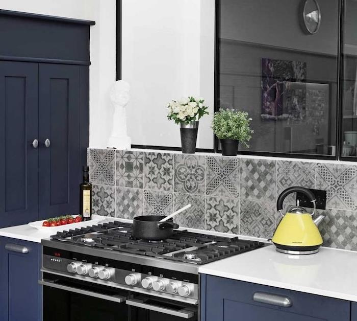 kök ommålat i marinblått, vit bänkskiva, grå, svartvita kakelplattor, färsk blommadekoration