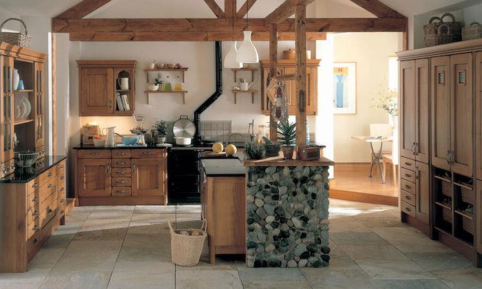 مطبخ خشبي ريفي مع عوارض مكشوفة وجزيرة خشبية مركزية مزينة بالحجارة وأرصفة حجرية وخزانة مطبخ خشبية