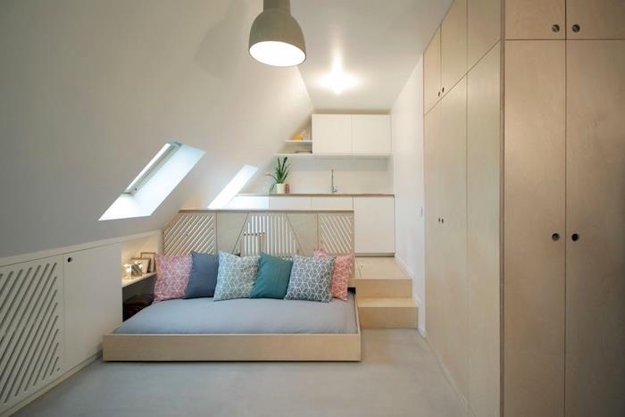 minimalistisk studiodesign med vitt vindkök, kokande träsäng med färgglada kuddar och trägarderob, studiolayout