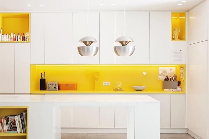 utrustat kök, exempel på kök med vit fasad och gullackerad stänk, original upphängningar i rostfritt stål, gul och vit bänkskiva