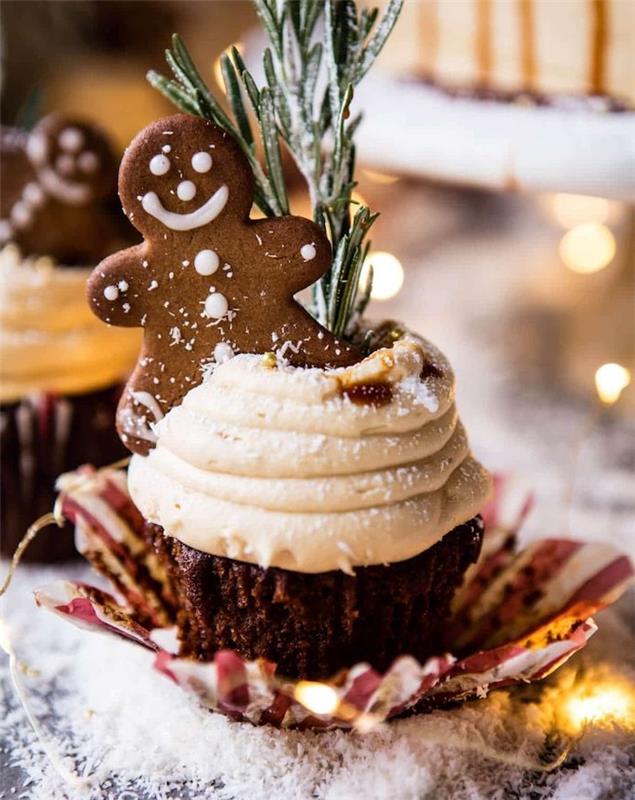 ingefära cupcake beredning med vispad grädde toppning och en bas av kakao och julpinnar, rosmarin dekoration och pepparkakor kaka