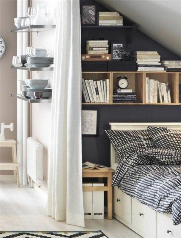 Deco -sovrum under sluttningen, antracitgrå accentvägg, vit säng med lådor, vita och svarta sängkläder, bokhylla, sängbord i trä