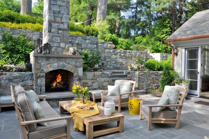 مدفأة حجرية خارجية ، فكرة حديقة ذات مناظر طبيعية ، تصميم شرفة حديقة بزهور جميلة ، طاولة قهوة خشبية وأثاث حديقة أريكة