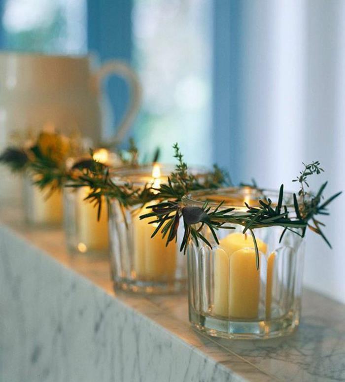 Vianočné dekorácie, ktoré si urobíte sami, priehľadné sklenené svietniky s veľkými bielymi sviečkami, vianočné ozdoba alebo na okraji okna