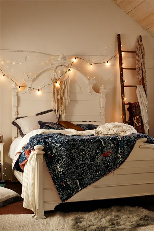 dekoration med ljusa kransar, vit säng, sluttande tak, barock sänggavel, bohemisk filt, dekorativ stege