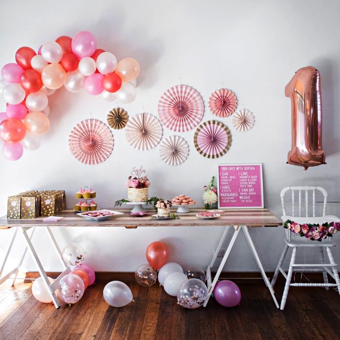 vägg av papperrosetter och ballongbåge för dekorationen av det söta gourmetbordet, födelsedagsflickabordsdekoration i rosa nyanser
