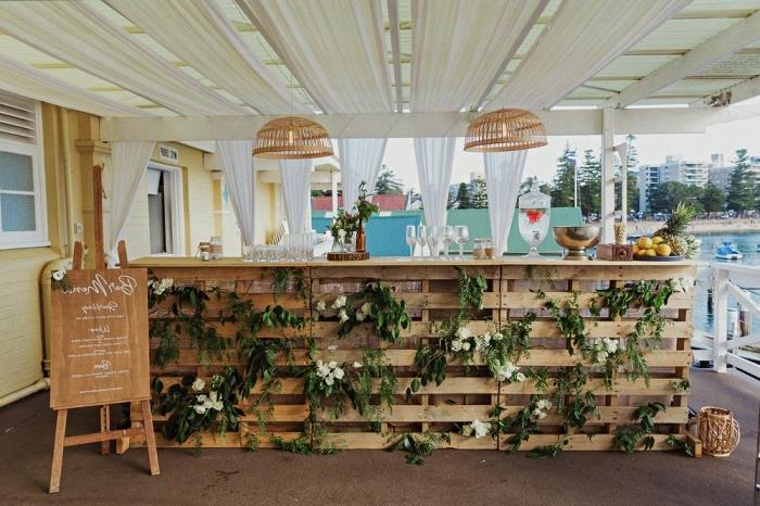 DIY bröllopsdekoration, champagnebardekoration i pallar med blommor och gröna grenar