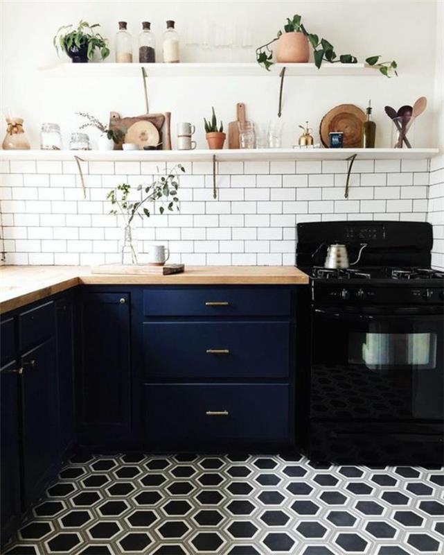 modrá kuchyňa, sivé t čierne obklady, biely tehlový obklad, biela polica s pohármi a riadom, čierny sporák