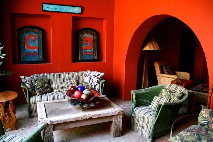 Rustik vardagsrumsinredning i etnisk stil, bohemisk provencalsk dekoration med röd vägg, vardagsrum i vintagekorg