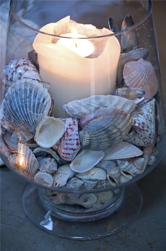 dekorationsvas vid havet med ljus fyllda med snäckskal
