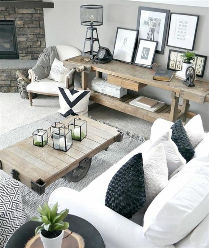 Skandinavisk rustik chic lantlig inredning, ett träbord med hjul, grå matta, vit soffa och grå och vita kuddar, inredning med ramar, öppen spis i sten,