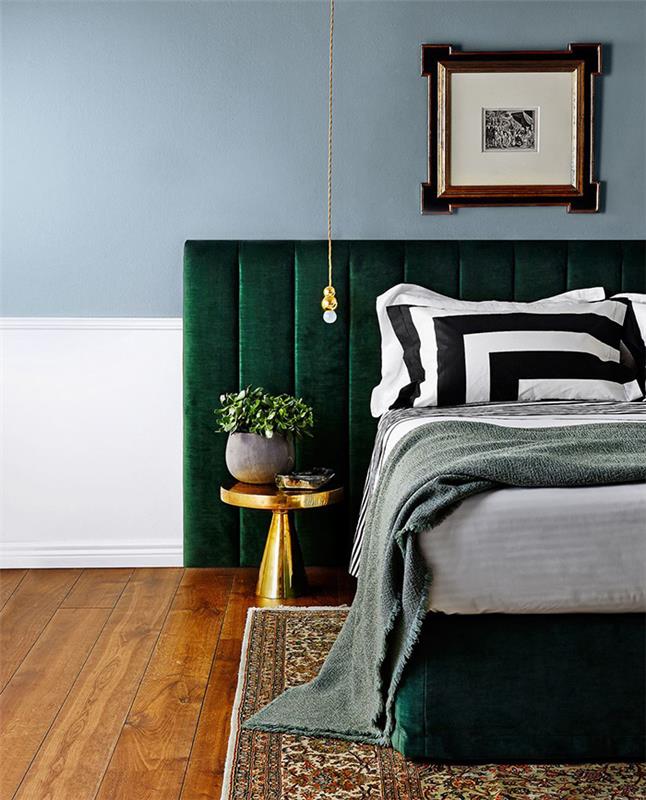 výzdoba spálne pre dospelých s modrou stenou, smaragdovo zeleným čelom, bielou, čiernou a sivou posteľnou bielizňou, orientálnym kobercom na hnedej parkete