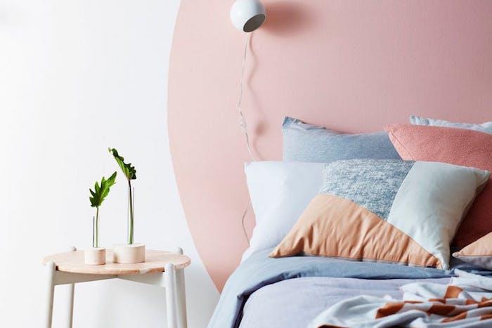 model dekorácie spálne pre cocoon, biela farba na stenu s ružovým kruhom ako čelo postele, ružová, šedá, lososová posteľná bielizeň, škandinávsky nočný stolík
