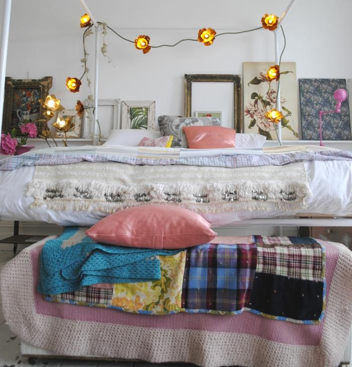 inramade målningar, ljus krans, rosa kuddar, romantiskt sovrum