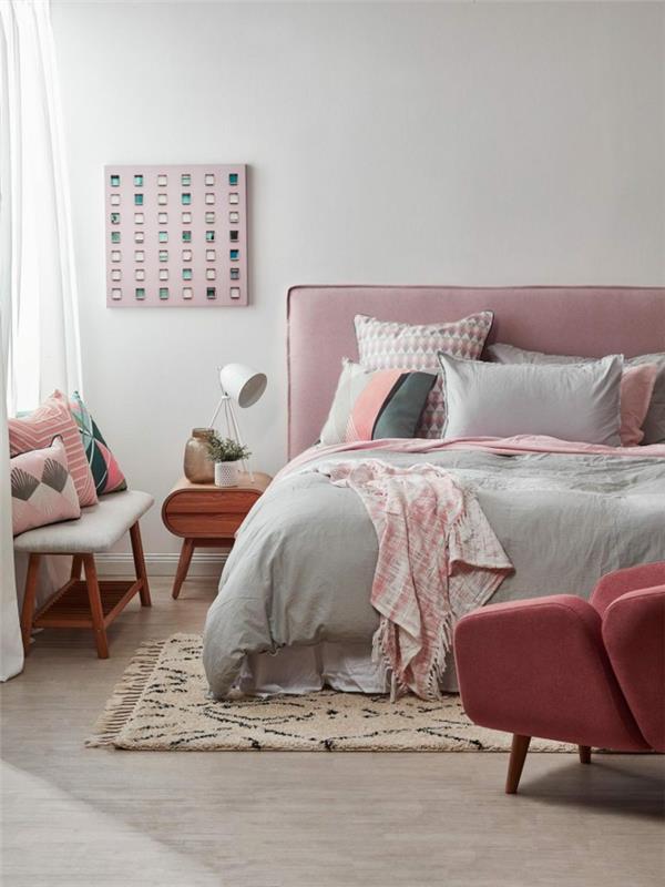 Berbermatta, grå och rosa säng, rosa fåtölj, nattduksbord i trä, sängduk i rosa tyg, ljusgrå vuxen sovrumsfärg