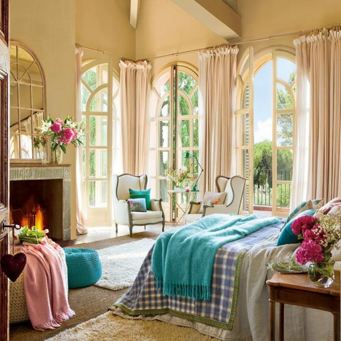 romantisk stol, rosa pläd med fransar, turkos pall, öppen spis, gulaktiga väggar, mjuk matta