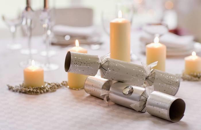 konfetti kanoner och pärlkrans runt olika ljus på grå och vit bordsduk