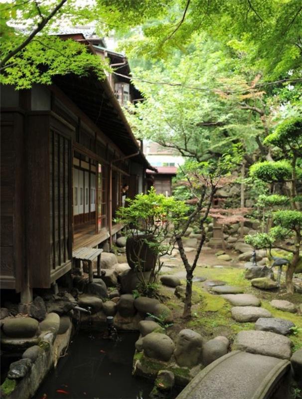 حديقة زن يابانية وحوض مائي للكارب وممرات حجرية وجسر حجري وأشجار ومنزل على الطراز الياباني