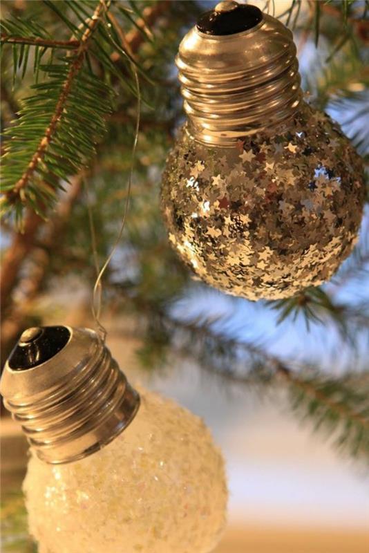 Vianočná ozdoba na výrobu malých žiaroviek v tvare hrušky, ozdobená malými striebornými hviezdičkami a bielymi prvkami, ktoré napodobňujú mráz na skle