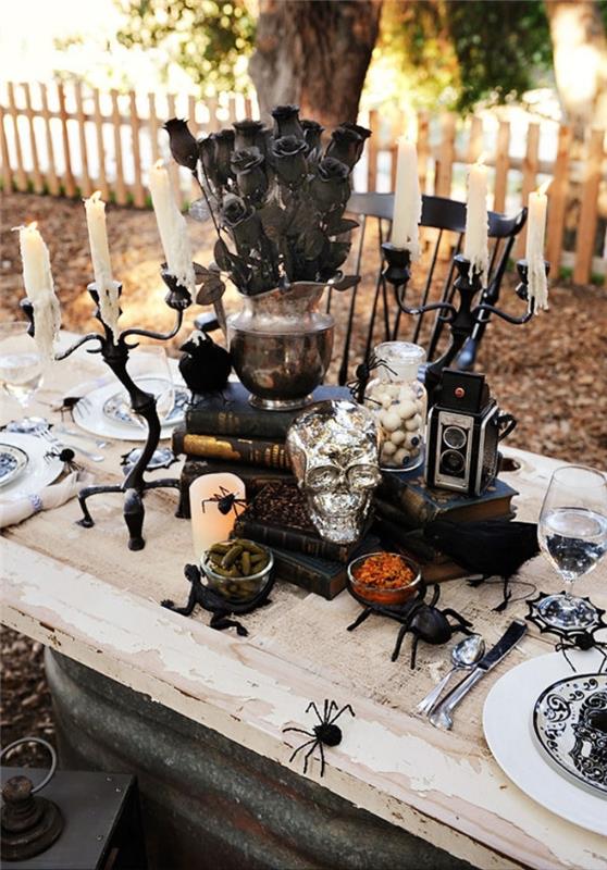 utomhus halloween fest organisation, halloween bord i vitt och svart med ljusstakar och silverskalle