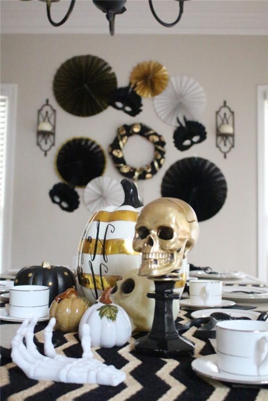halloweenmåltid, idé hur man ordnar halloweenbordet i vitt svart och guld, vitmålat pumpamönster med gyllene linjer