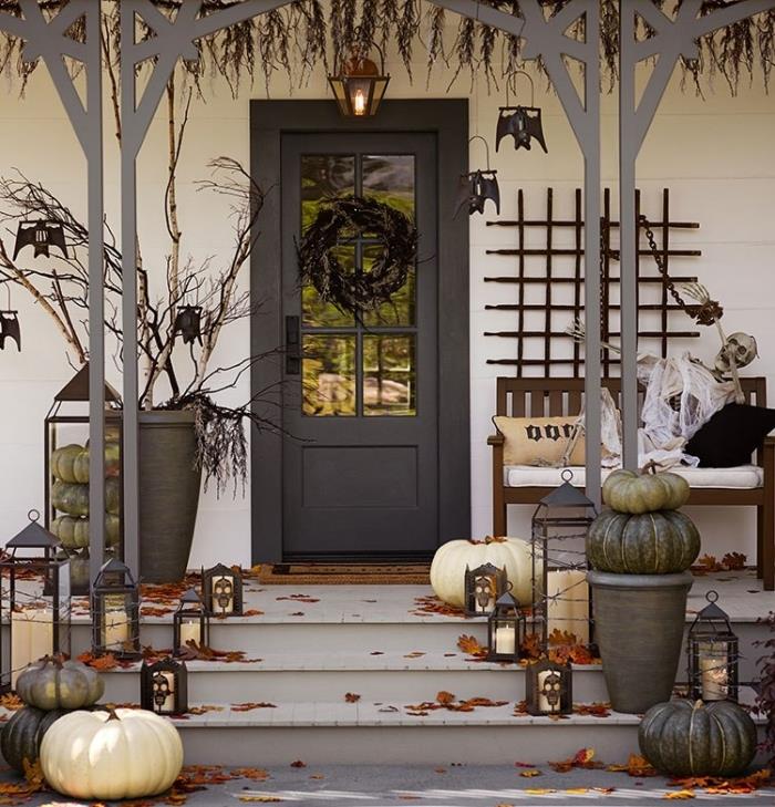 halloween stil ytterdörr och veranda, vita och grå pumpor med svarta lyktor och vita ljus