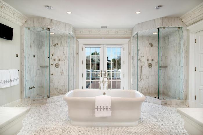حمام حديث ، جدار زجاجي ، بلاط رخامي ، حوض استحمام أبيض ، منشفة بيضاء