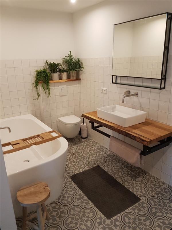 kúpeľňa s cementovými dlaždicami s veľkými arabeskovými vzormi, ktoré dodávajú príjemnú atmosféru tejto kúpeľni, s vaňou s priemyselnými akcentmi