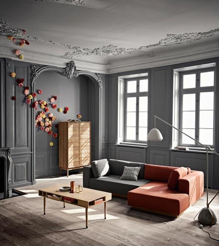dekoračný salón-sivá-luxusná farba-obývačka-sivá sedačka-v-šedej a červenej-drevenom-konferenčnom stolíku-pekná-dekoratívna-kvety-na-stene