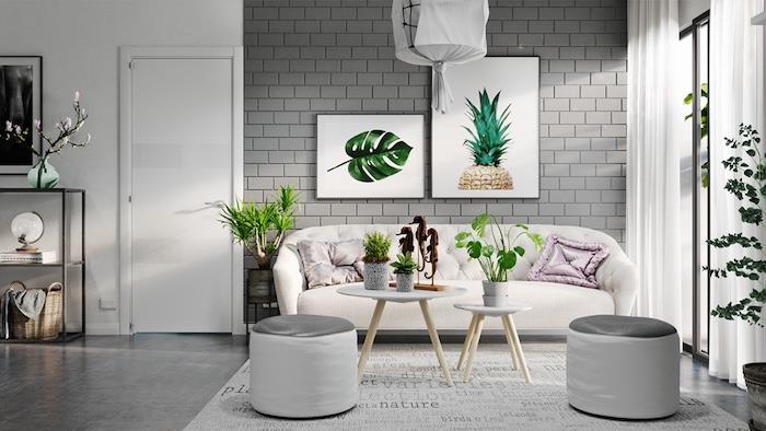 sivá a biela dekorácia obývačky s bielou sedačkou, škandinávske drevené konferenčné stolíky, sivá podlaha, sivé a biele taburetky, dotyk zelene s niektorými kvetináčmi, nástenná dekorácia rámov rastlín