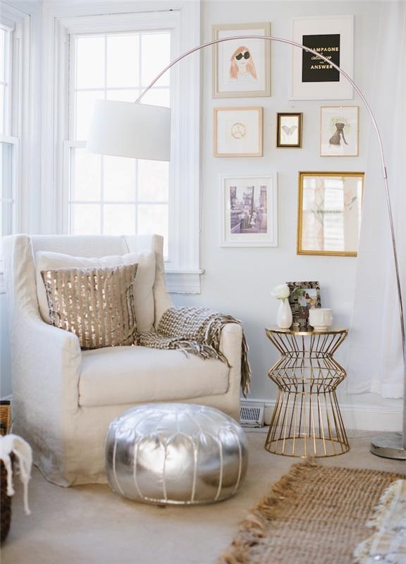 dekor obývačky s bielym kreslom, strieborná pufová stena zdobená rámami a mosadzným stolíkom, rohový bočný okenný bok