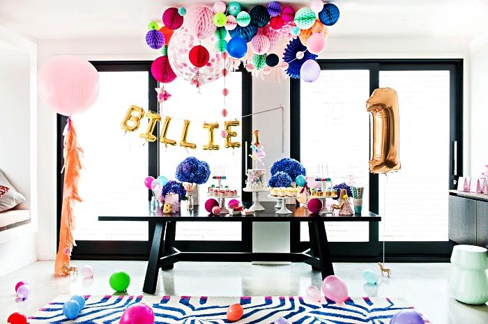 födelsedagsbord dekorerat med en krans av ballonger och bikakebollar, barnfödelsedagsdekor