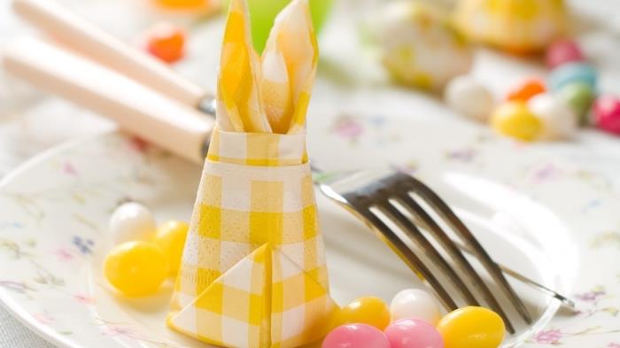 hur man viker pappersservetter för att dekorera ett påskbord, gula och vita rutiga servetter vikta i påskhare