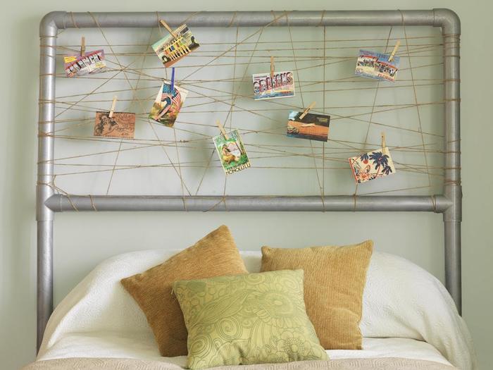 deco -sänggavelram dekorerad med korsade trådar med små färgglada landskapskort, vita sängkläder och beige dekorativa kuddar
