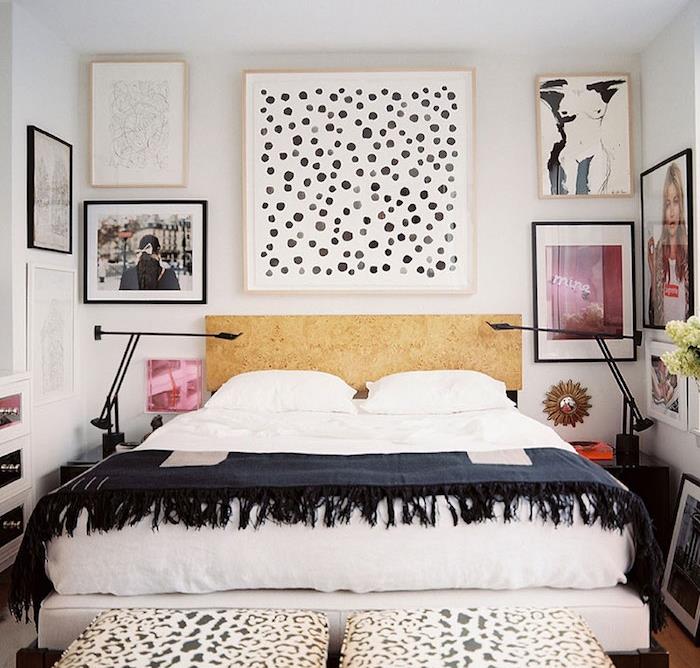 sänggavelpanel i trä med fotoramar och teckningar runt, vita sängkläder och marinblått sängklädsel