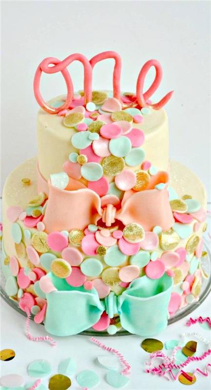 كعكة مصممة مزينة بشرائط و قصاصات من عجينة السكر ، الفكرة الأصلية لكعكة عيد ميلاد مذهلة لفتاة عمرها سنة واحدة