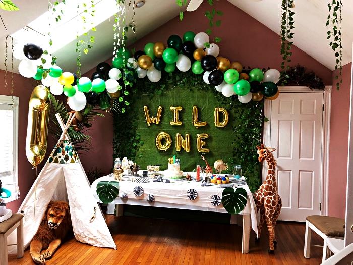 Indisk tipi, ballongbåge och grön bakgrund för en pojkes födelsedagsdekoration på temat djungeln