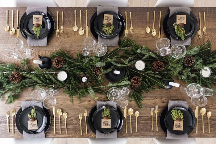 Julbord mittpunkt dekoration i gran grenar vita ljus mörkt trä bord naturliga material
