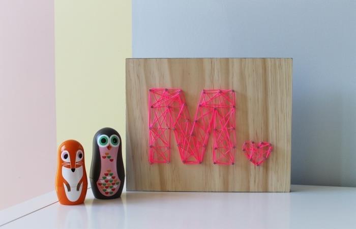 exempel på barnrumsarrangemang med tillbehör och handgjorda föremål, modell av träpanel med bokstaven M i tråd och spik