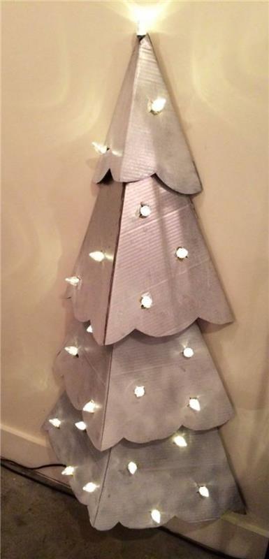 ručne vyrábaná vianočná dekorácia, vianočný stromček so svetlou girlandou pripevnený k stene
