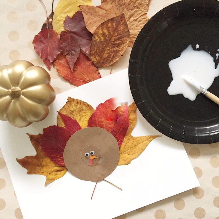 نشاط حضانة الخريف ، إنشاء ديك رومي في دائرة من ورق الكرافت والريش في الأوراق المتساقطة ، فن الأرض DIY