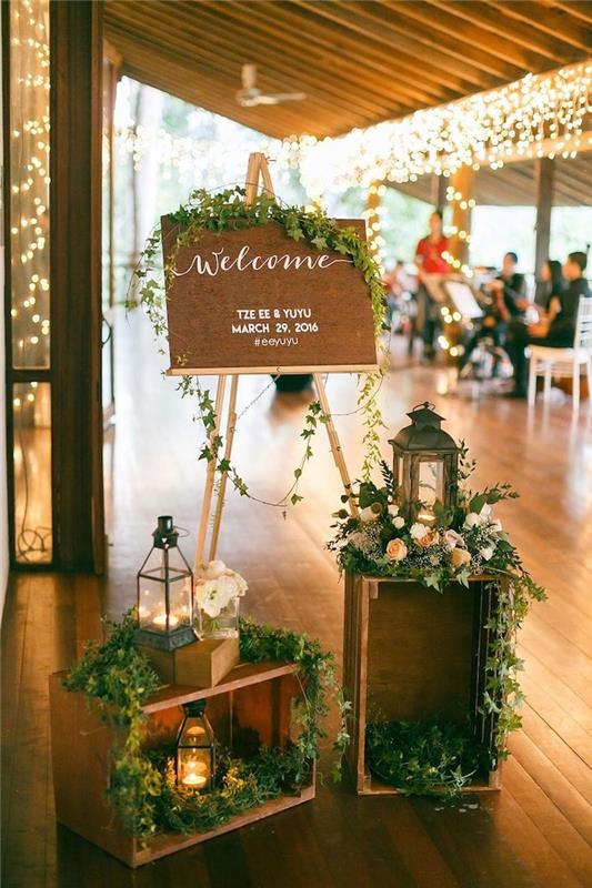 svadobný uvítací stôl výzdoba kvetinové svadobné prepravky a dekoračné lampáše, nápady na svadobnú výzdobu vintage